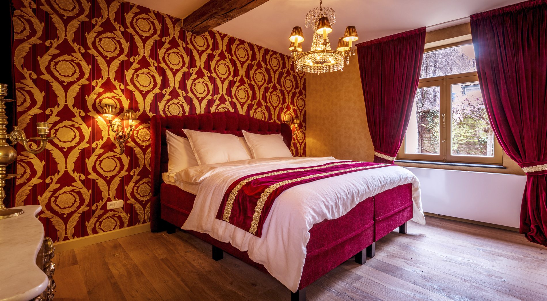 The red and gold bedroom with chandelier