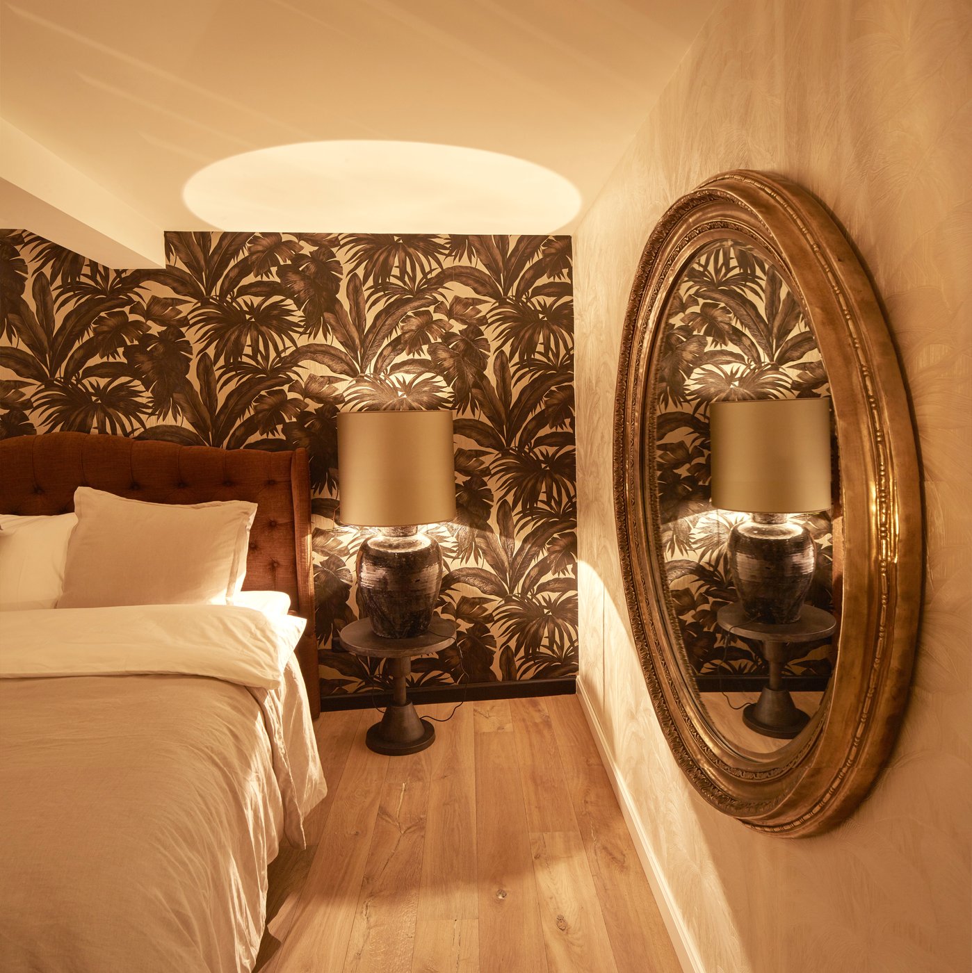 Gilt oval mirror reflecting the room